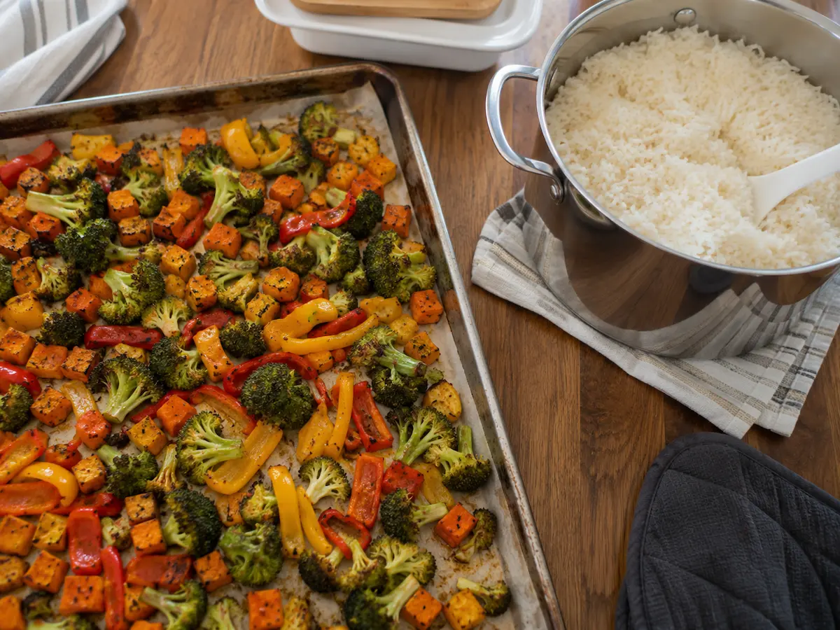 Meal prep Sunday — sheet pan roasted vegetables and a pot of rice cooling on the stovetop